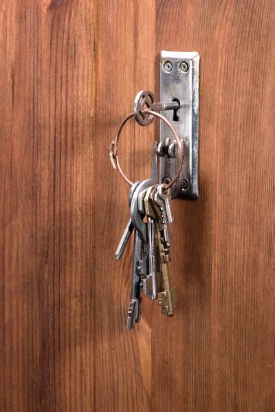 Retro key on the bunch is inserted into the keyhole — Stock Photo, Image