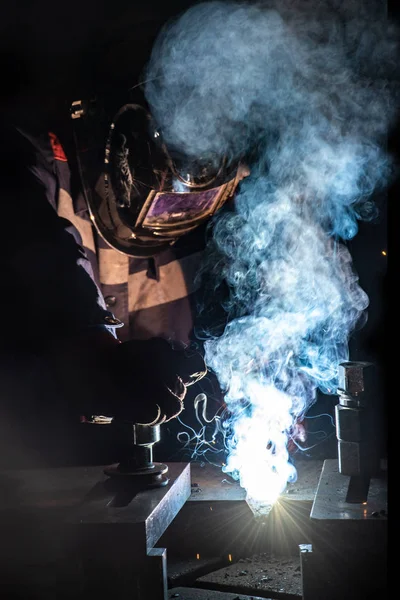 Arbeiter schweißt Metallkonstruktionen durch Lichtbogenschweißen — Stockfoto