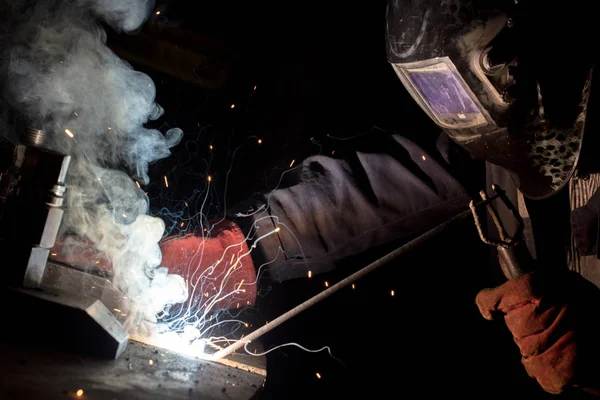 Trabalhador solda estruturas metálicas por soldagem a arco elétrico — Fotografia de Stock