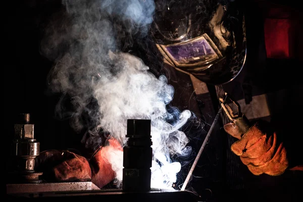 Arbeiter schweißt Metallkonstruktionen durch Lichtbogenschweißen — Stockfoto