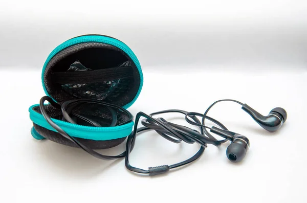 Черные наушники для прослушивания музыки и звука на портативных устройствах: музыкальный проигрыватель, смартфон, ноутбук и разъем для подключения на белом фоне. Затычки для ушей . — стоковое фото