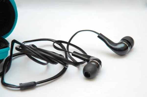 Auriculares negros para escuchar música y sonido en dispositivos portátiles: reproductor de música, smartphone, laptop y jack para conectar sobre fondo blanco. Tapones para los oídos . —  Fotos de Stock