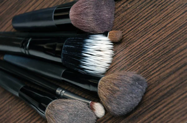 Мягкие кисти макияжа и маскара на черном фоне — стоковое фото