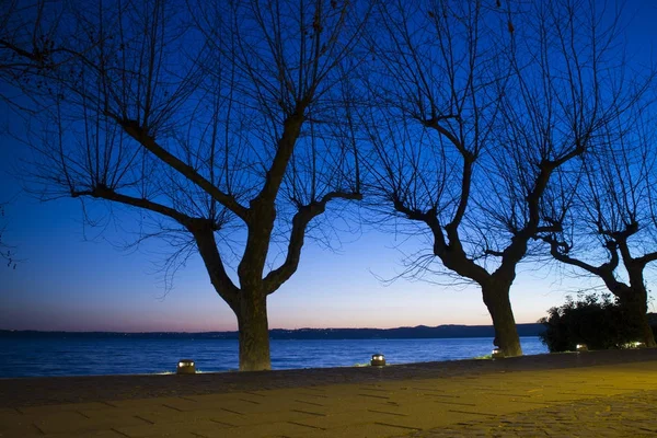 Paseo marítimo de Trevignamo en el lago en invierno al atardecer —  Fotos de Stock