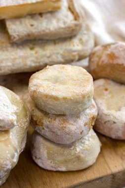 Bir sürü küçük yuvarlak keçi peyniri. Mandıra ürünleri tezgahta. Dikey fotoğraf, gün ışığı