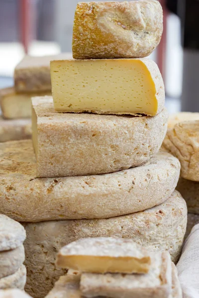 一大块奶酪放在奶酪的头上 到处都是各种各样的工匠奶酪 在市场上出售奶酪 — 图库照片
