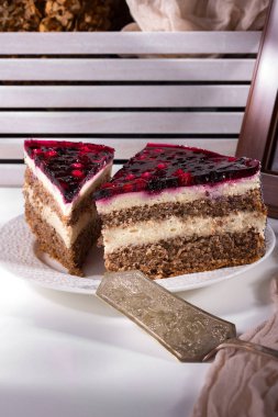 Cakes on a white plate, next to a graceful metal spatula and brown gauze