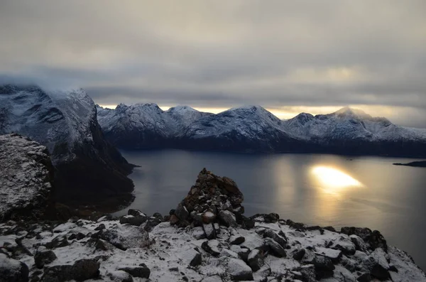 Dağın tepesinden muhteşem bir gün batımı, gökte güneş yoktur, sadece sudaki yansıması vardır.