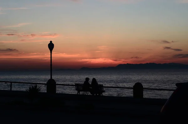 Silhouette Von Zwei Personen Die Während Des Sonnenuntergangs Auf Einer — Stockfoto
