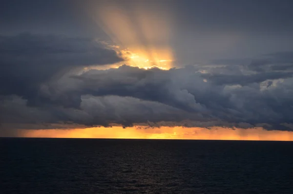 Bulutları delen uzun ışınlarla şaşırtıcı gün batımı