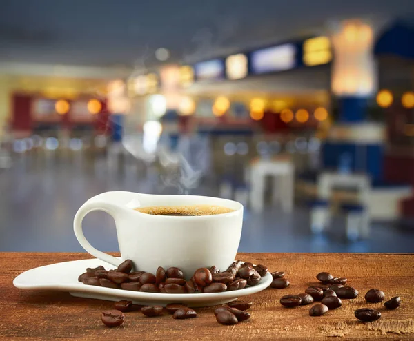 Ceașcă de cafea fierbinte pe fundal blur cafe — Fotografie, imagine de stoc