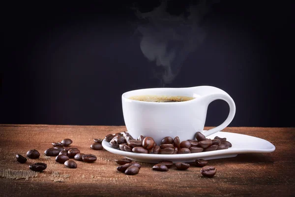Xícara de café com grãos de café no fundo preto — Fotografia de Stock
