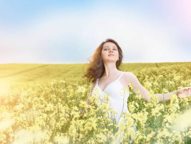 Alan yaz gün batımında Sarı çiçekli kadın.