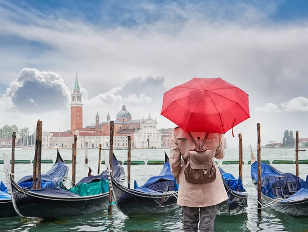Mujer con un paraguas rojo mirando a la iglesia de San Giorgio Maggiore, Venecia, Italia — Foto de Stock