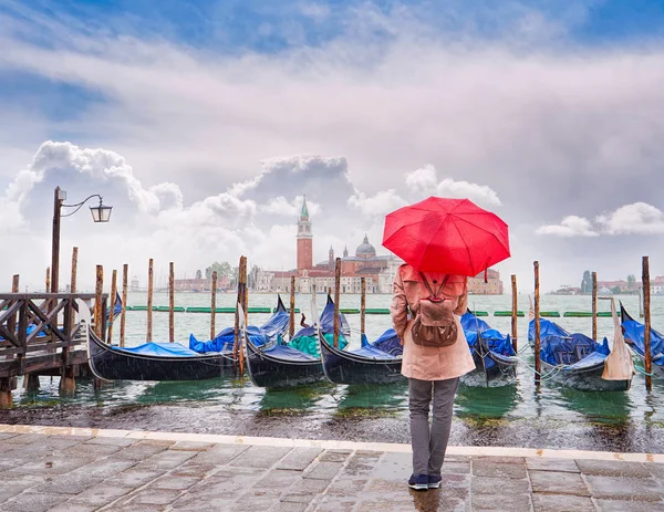 Mujer con un paraguas rojo que mira a la vista panorámica del Canal Grande con la iglesia de San Giorgio Maggiore, Venecia, Italia — Foto de Stock