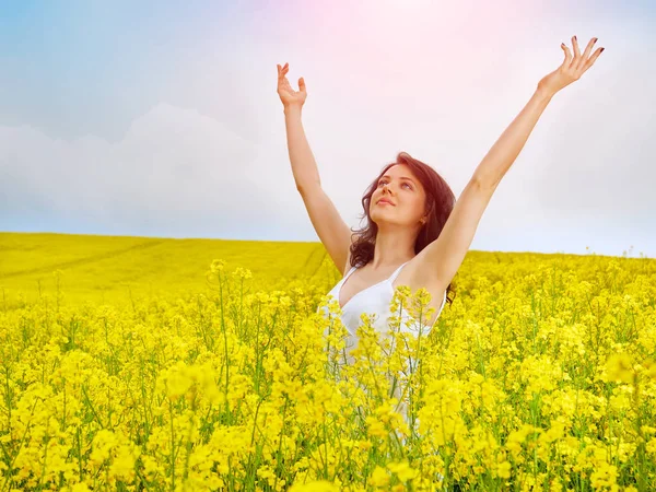 Woman in field with yellow flowers at summer sunset. — Stock Photo, Image