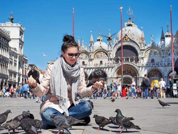 Hermosa mujer joven alimentando palomas en la Piazza San Marco — Foto de Stock