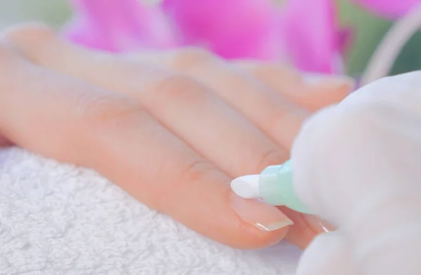 Primer plano de las manos femeninas consiguiendo manicura de uñas en una toalla —  Fotos de Stock
