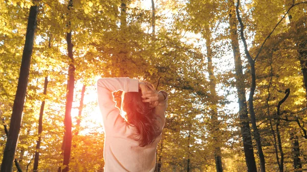 Kobieta z podniósł ręce do góry w lesie jesienią — Zdjęcie stockowe