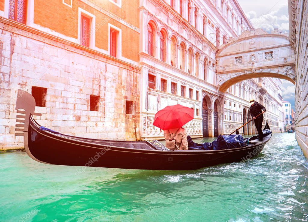 Female traveler in Gondola passing over Bridge of Sighs in Venice