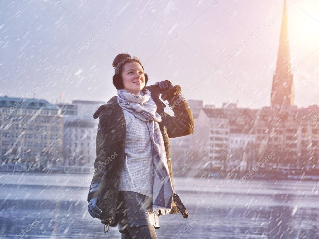 Young beautiful girl enjoying with snowing at Alster Lake in Hamburg city