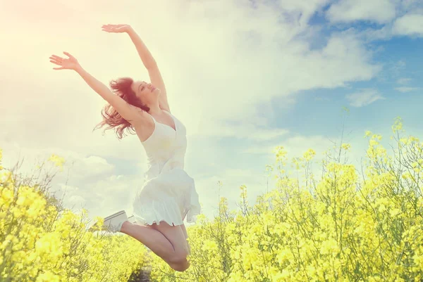 Mujer Saltando en el campo amarillo. Imagen tonificada — Foto de Stock