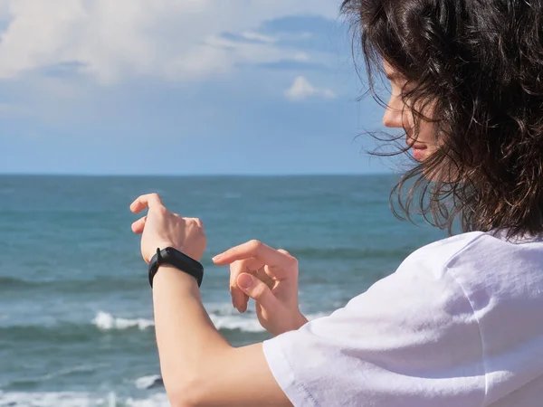 Kvinna tittar på pulsmätare klocka utanför jogging på stranden. — Stockfoto