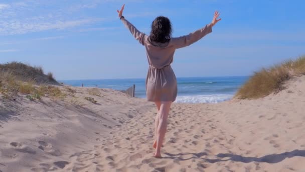 Mujer caminando con los brazos hasta la playa de verano durante los viajes de vacaciones — Vídeo de stock