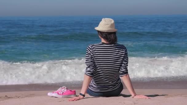 Αναπαύεται γυναίκα στην παραλία Θαλασσινά νερά και καθαρός ουρανός. — Αρχείο Βίντεο