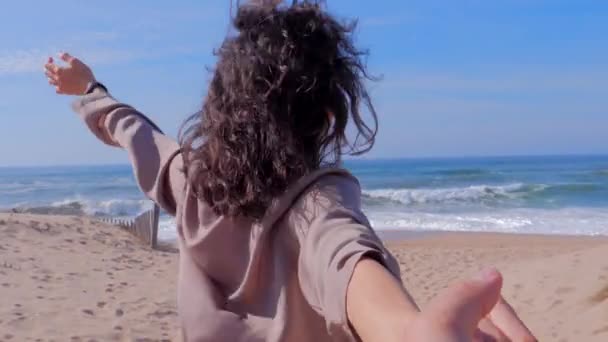 Женщина ведет мужчину за руку к пляжу — стоковое видео