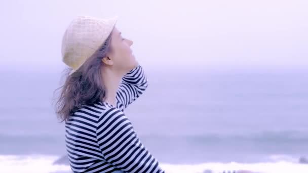 Mujer de ojos azules divirtiéndose en un día nublado lluvioso en la playa — Vídeo de stock