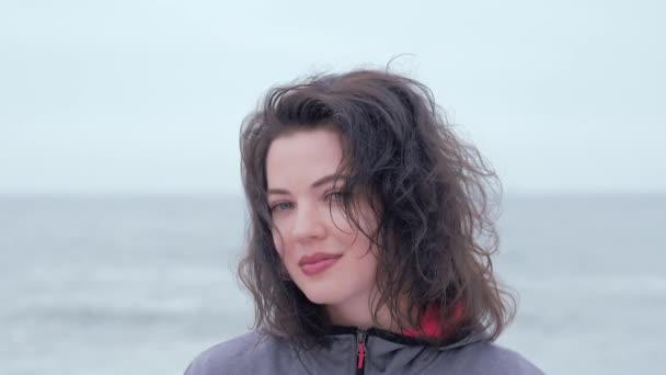 Portrait d'une femme aux yeux bleus par une journée nuageuse à la plage — Video