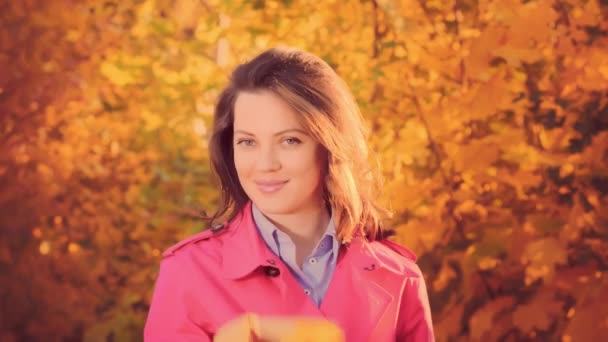 Joven mujer sonriente con hoja de otoño amarillo, tiempo de otoño — Vídeos de Stock