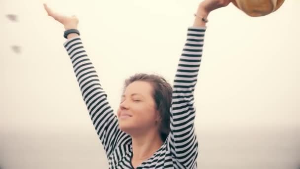 Счастливая женщина на пляже наслаждается дождём в серый дождливый день . — стоковое видео