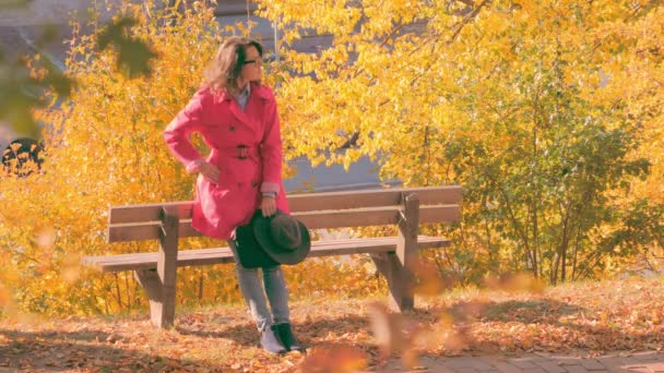 Frau schaut auf Smartphone und wartet im Park auf jemanden — Stockvideo