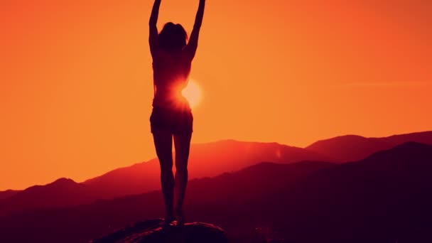 Silueta femenina bailando al atardecer sobre el fondo de la montaña — Vídeo de stock