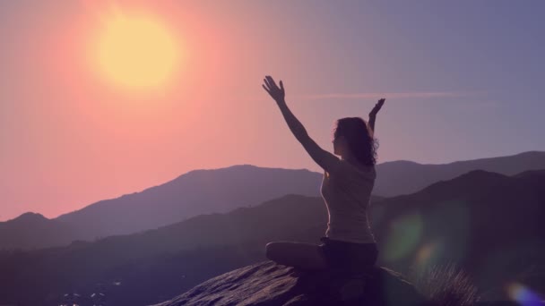 Ung praktiserande kvinna utövar yoga på bergstoppen — Stockvideo