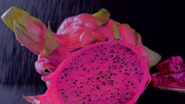 Wet Cutting Pitahaya, dragonfruit on a black background, close-up rotation — Stock Video