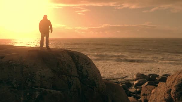 Hombre en la cima de la montaña disfrutando de vista al mar — Vídeo de stock