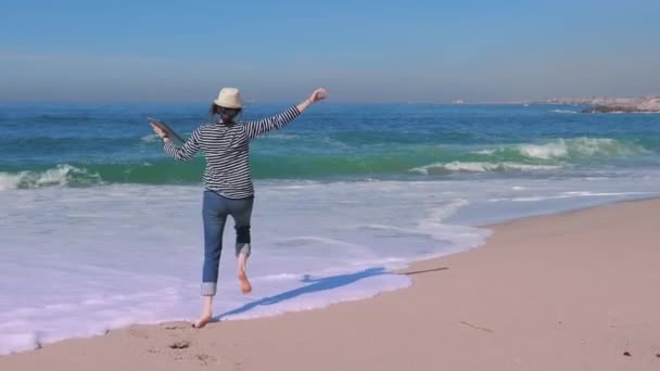 Hermosa mujer con portátil recibiendo buenas noticias en la playa. Mujer viajera feliz — Vídeos de Stock