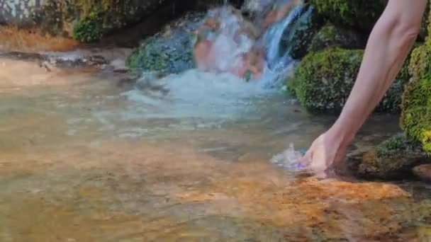 Mujer tomando agua cruda de una fuente natural en una botella — Vídeo de stock