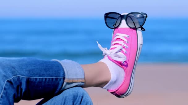 Sunglasses on the womans foot on a blue background of sea water and clear sky – Stock-video