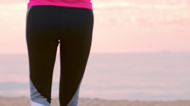 Mujer en aptitud en la orilla del océano. Mujer que corre a lo largo de un sendero de madera — Vídeos de Stock