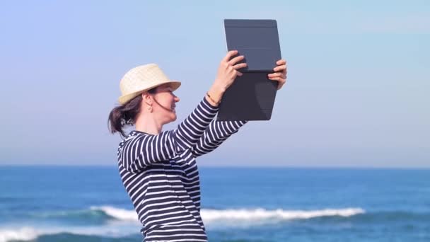 Happy woman chatting online with her friends on sunny beach — 비디오