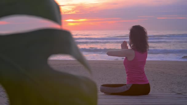 Junge Frau meditiert am tropischen Strand — Stockvideo