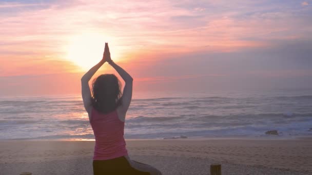 Kvinna utövar yoga på stranden, vacker sommar solnedgång — Stockvideo