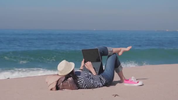 Mujer acostada en la playa de arena, trabajando fuera, tiempo de vacaciones — Vídeos de Stock