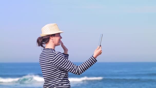 Femme discutant en ligne avec ses amis sur une plage ensoleillée — Video