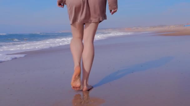 Kvinna promenader på sandstrand, hav vågor på bakgrunden, baksida — Stockvideo