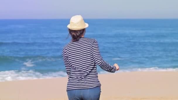 Žena šťastný úsměv radostný s rukama nahoru tanec na pláži během dovolené cestování. — Stock video